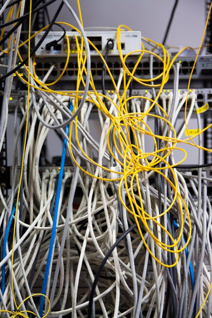 pexels-photo-12266914 Close-up of tangled network cables and wires in a server room, showcasing technological chaos.